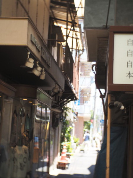 横浜橋商店街の路地裏、錆びたベランダが見える建物の間から撮影