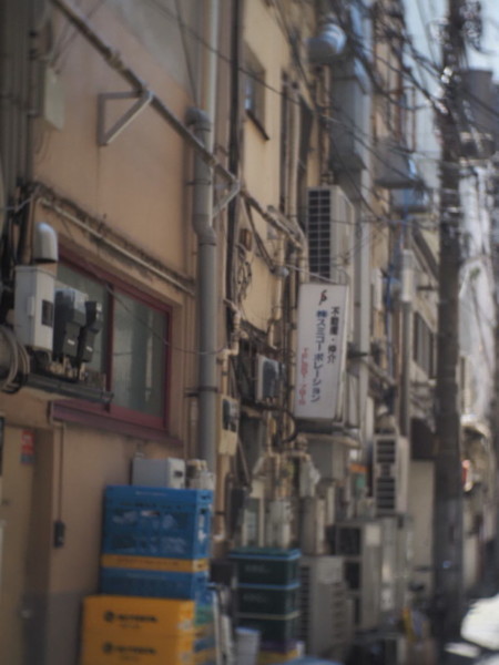 伊勢佐木町商店街の路地裏、排気口や湯沸かし器が雑多に並んだビルの壁