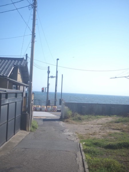 稲村の路地、横断歩道と赤信号の向こう側に海が広がる画像