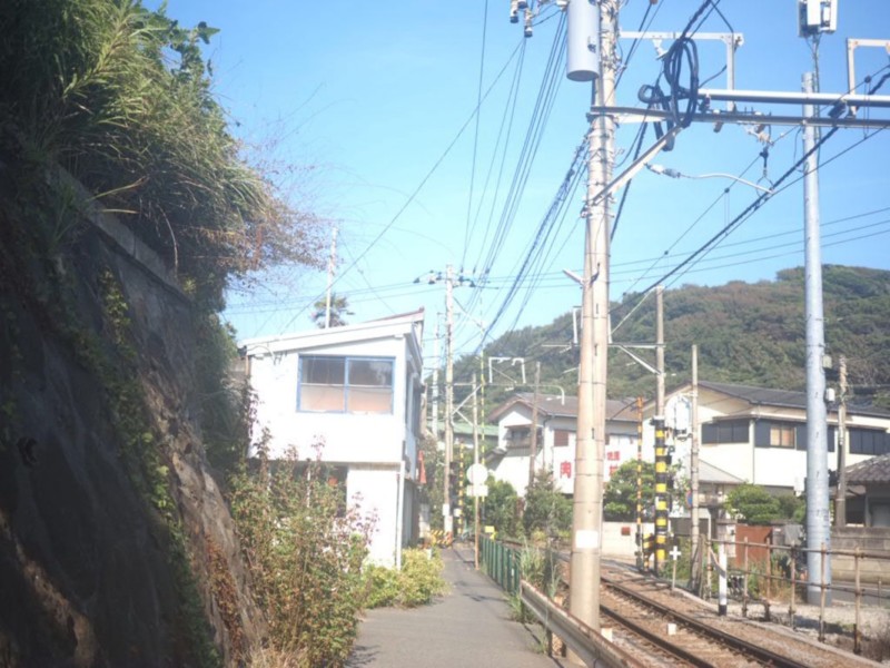 小さな小道と線路が隣り合わせになっている稲村ヶ崎の踏切