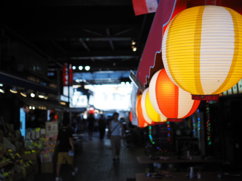 アメ横のガード下の風景、居酒屋の黄色・オレンジの提灯を手前に奥へお店が広がる風景