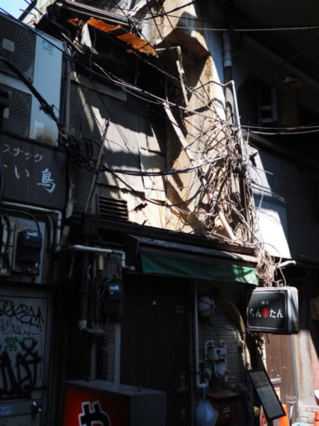 アメ横の路地裏の写真、配線が入り乱れた薄暗い通り