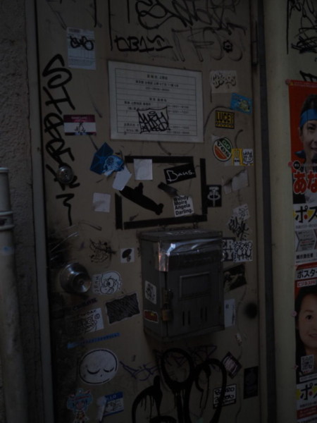 アメ横のガード下の風景、グラフィティアートやステッカーが貼られたポスト