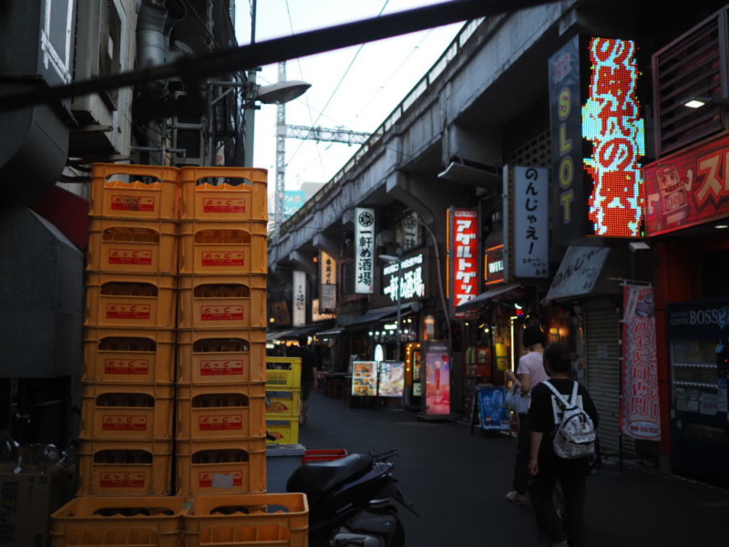 アメ横のガード下、ホッピーのプラ箱の向こうに広がる居酒屋の風景