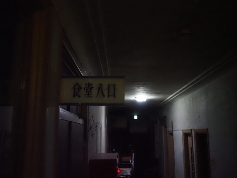 旅館内の暗闇に浮かぶ食堂入口の看板