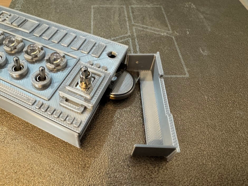 5つのトグルスイッチをひたすらパチパチできる装置の電池交換の様子