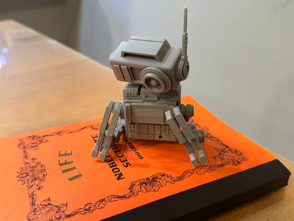 レトロなノートの上にちょこんと鎮座しているドロイドの写真