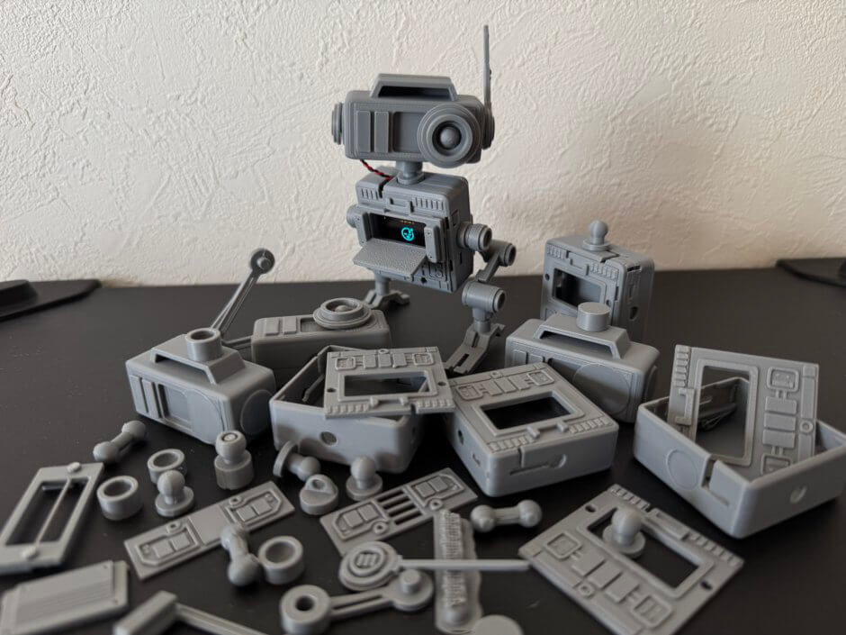 失敗したたくさんのパーツの山の上に完成したドロイドがこちらを向いている写真