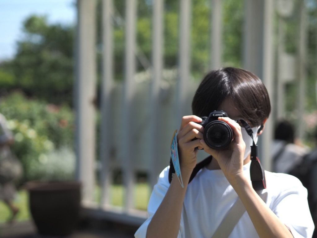 少年が一眼レフを構えている写真