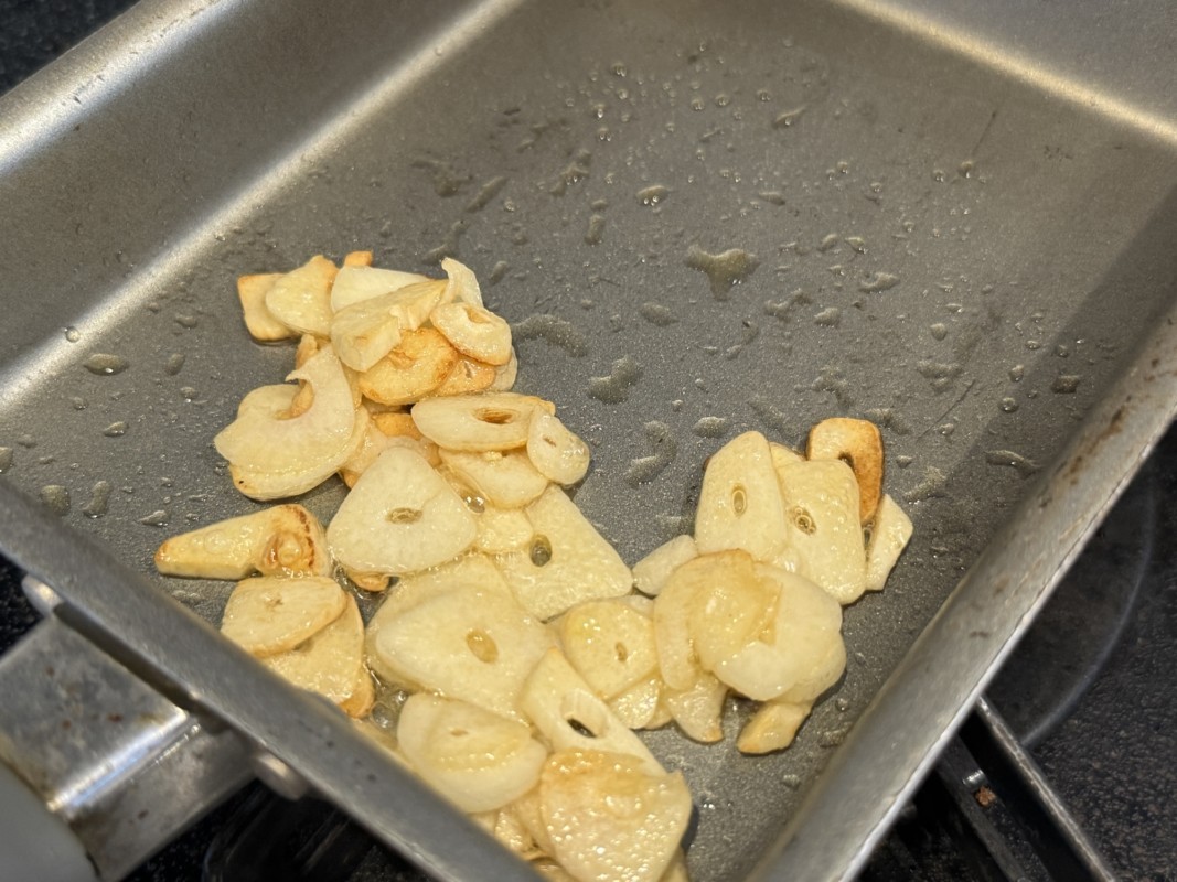 ニンニクをごま油で揚げる