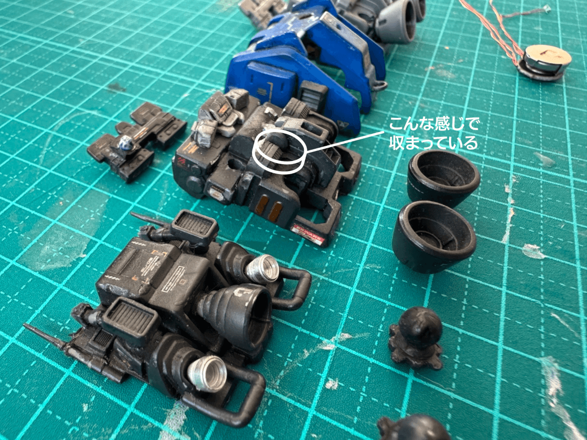 小型宇宙船のプラモデルを一度解体してボタン電池がどこに入っているかを説明している写真